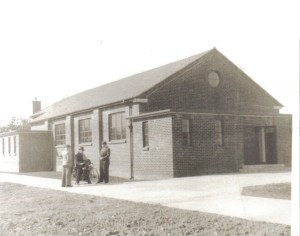 Father Gerard Bilsborrow on his motorbike chatting to parishioners circa 1953